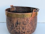 a large copper pot sitting on a white surface