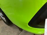 a close up of a green car with a sticker on it