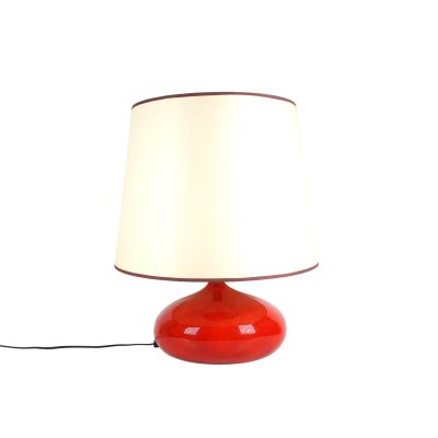 a red table lamp with a white shade on it