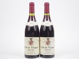 deux bouteilles de vin rouge posées l'une à côté de l'autre sur une surface blanche