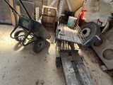 un tas de vieilleries dans une pièce où se trouvent une brouette et un banc en bois