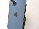 a blue iphone sitting on a stand on a white surface