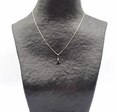 un collier noir et blanc orné d'une croix, porté par un mannequin