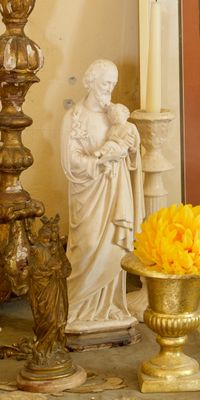 une statue de Jésus et un vase de fleurs posés sur une table