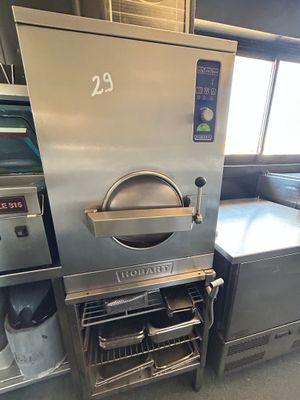 un four argenté posé au milieu d'une cuisine, à côté d'une table