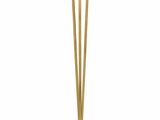 a gold floor lamp with a glass shade on top of it