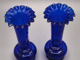two blue vases sitting on a white table