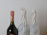 une bouteille de champagne posée à côté de deux sacs sur une table
