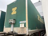 un grand fourgon vert orné d'un logo « z » jaune