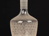 a clear glass bottle sitting on top of a wooden table