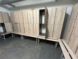several wooden lockers are lined up in a room with concrete flooring