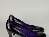 un gros plan sur une paire d'escarpins noirs et violets