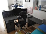 a desk with a computer and a chair in a room