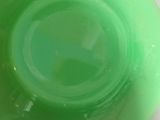 underside view of a green glass bowl on a white surface