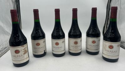 six bouteilles de vin sont alignées sur une table