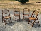 four wooden chairs are arranged in a circle in a gravel lot