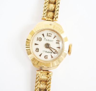 gros plan d'une montre-bracelet en or sur une surface blanche