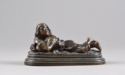 bronze statue of a woman laying on her stomach on a base