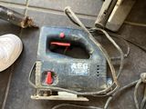 a small corded sander on the floor next to a pair of shoes