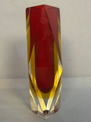 un vase rouge orné d'une bande jaune