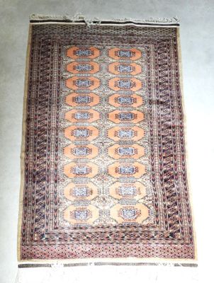 un vieux tapis posé à même le sol, sur fond blanc