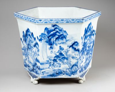 a blue and white vase with a mountain scene on it