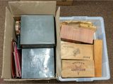 une boîte remplie de livres et de papiers posée par terre