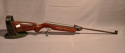 an old rifle is sitting on a white surface with a keychain