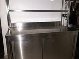 a stainless steel counter in a kitchen with a trash can
