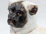a white and black dog figurine on a white surface