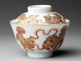 a close up of a white and red vase with a dragon on it