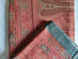 a close up of a red and green scarf on a white table