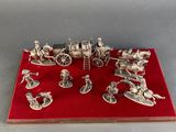 a silver figurine of a horse drawn carriage with people on it