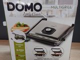 La boîte d'un multi-grill est ouverte sur la table.