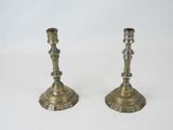 pair of antique brass candlesticks on a white background