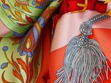 a close up of a colorful scarf with a tassel on it