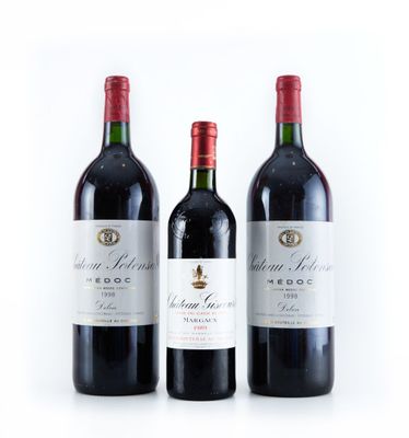 trois bouteilles de vin rouge posées l'une à côté de l'autre sur une surface blanche