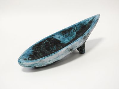 un petit bol bleu posé sur une table blanche