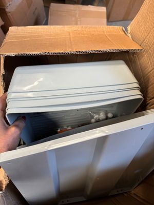 a person holding a box with a microwave inside of it