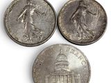 three silver coins of the united states, one of which is a woman and one of which is a man