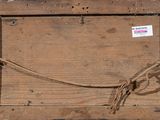 a wooden box with a rope around it and a sign attached to it