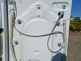 a white bath tub with a hose attached to it
