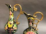 two vases with floral designs on them sitting next to each other