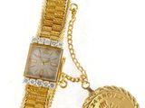 a close up of a wrist watch with a coin attached to it
