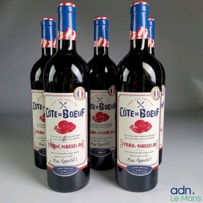 trois bouteilles de vin rouge posées sur une table blanche