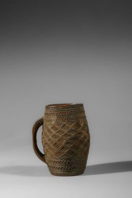 une image représentant une tasse marron avec une anse posée sur une surface blanche
