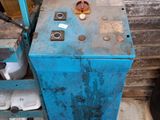a blue cabinet with a metal door next to a trash can and a trash can