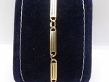 a close up of a gold bracelet on a blue velvet case