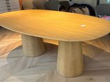 une grande table en bois au milieu d'une pièce
