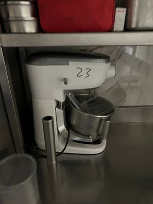 un plan de travail en acier inoxydable sur lequel sont posés un mixeur et des seaux